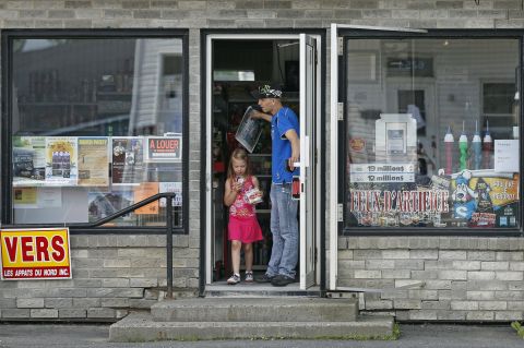 Residents leave a convenience store in a part of Lac Megantic that reopened on July 9.