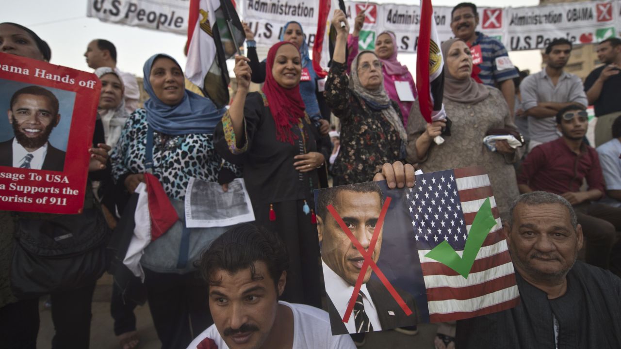 Egyptians in Tahrir Square hold posters and banners on Sunday expressing love of Americans and dislike of President Obama.