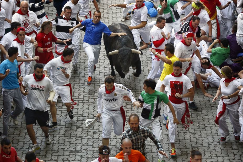 Revelers run alongside a bull in the streets on Wednesday, July 10. 