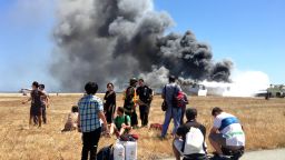 In this Saturday, July 6, 2013, photo provided by passenger Benjamin Levy, passengers from Asiana Airlines flight 214, many with their luggage, on the tarmac just moments after the plane crashed at the San Francisco International Airport in San Francisco. The flight crashed upon landing, and two of the 307 passengers aboard were killed. (AP Photo/Benjamin Levy)