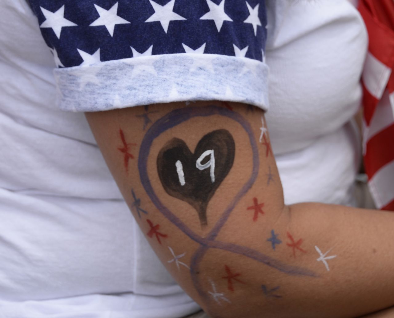 A woman wears a painted "19" in memory of the firefighters during a memorial service in Prescott Valley, July 9.  