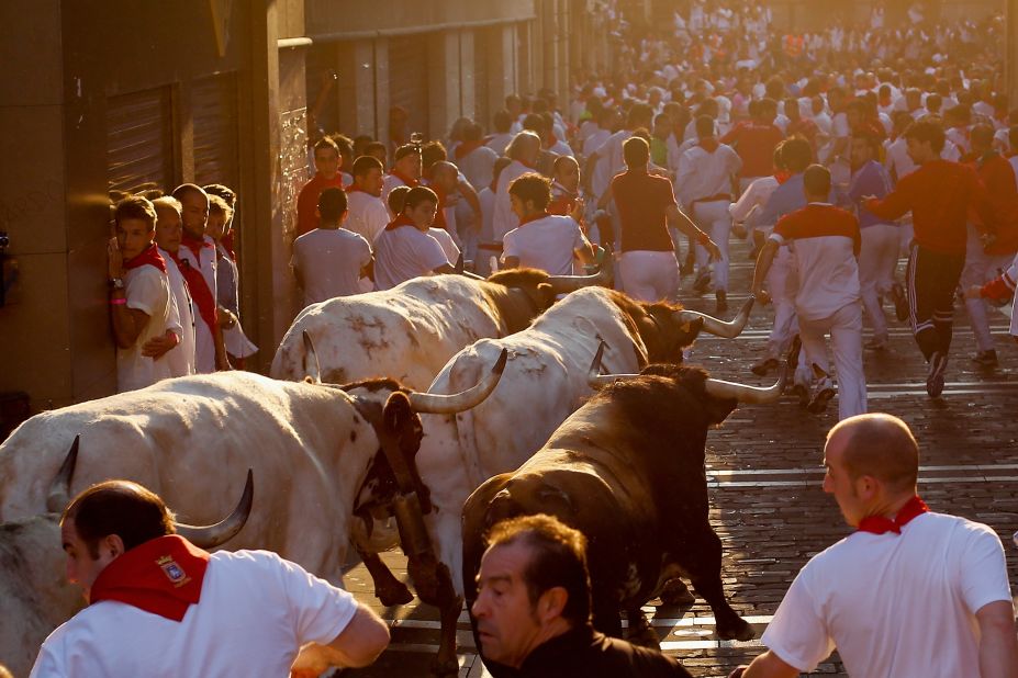 Revelers run with fighting bulls on July 11.