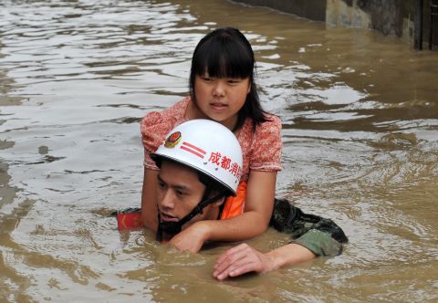 A rescuer helps a woman escape the floodwaters of the Tuo on July 11.