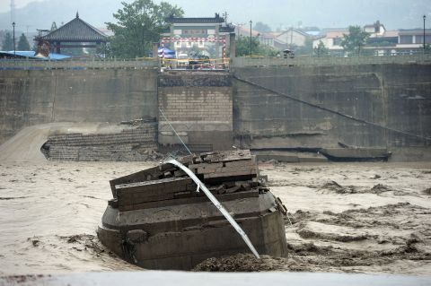The ruins of the collapsed Panjiang Bridge, also called Qinglian Bridge, lie in a flooded river in the city of Jiangyou on July 9.