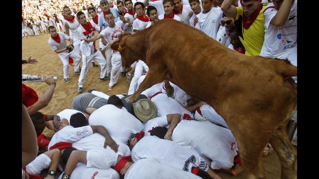 A bull jumps over revelers in the ring at the end of the fifth run on July 11.