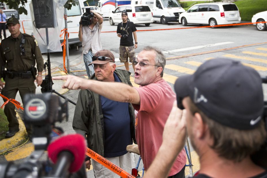 Protesters shout at rail executive Ed Burkhardt. The town is seething with anger.