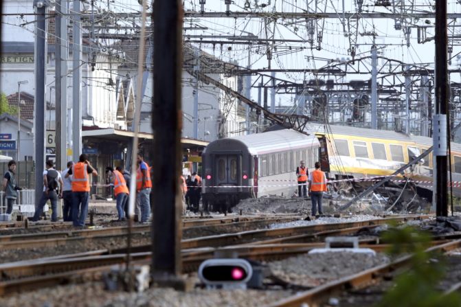 Rescuers work on the site of a train accident in the railway station of Bretigny-sur-Orge, on Friday, July 12 near Paris. The train was passing through the station but was not scheduled to stop there, according to Guillaume Pepy, president of the French national railway company, SNCF.