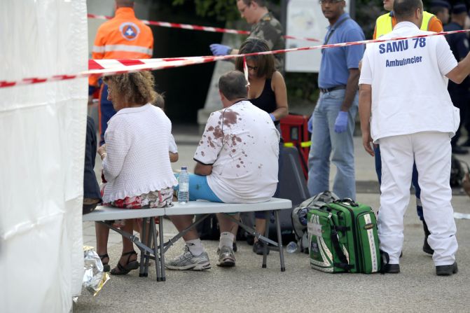 People injured in the accident wait for medical assistance on July 12, near the scene of the accident.