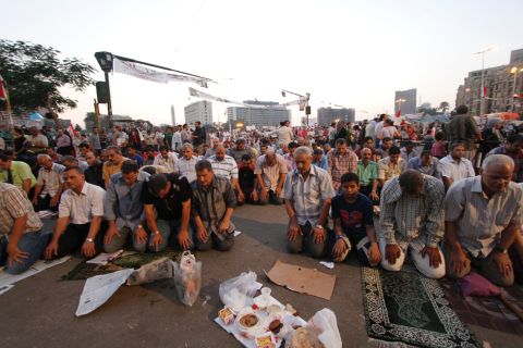Egyptians in Cairo's Tahrir Square pray before breaking their fast on the third day of Ramadan, the sacred holy month for Muslims, on Friday, July 12.  