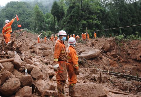 Rescuers work at the site of a massive landslide in Dujiangyan in southwest China's Sichuan province on Friday, July 12. The landslide killed at least 43 people and left 118 missing. The flooding that triggered the landslide has affected 1.5 million people and inundated tens of thousands of acres of crops. 