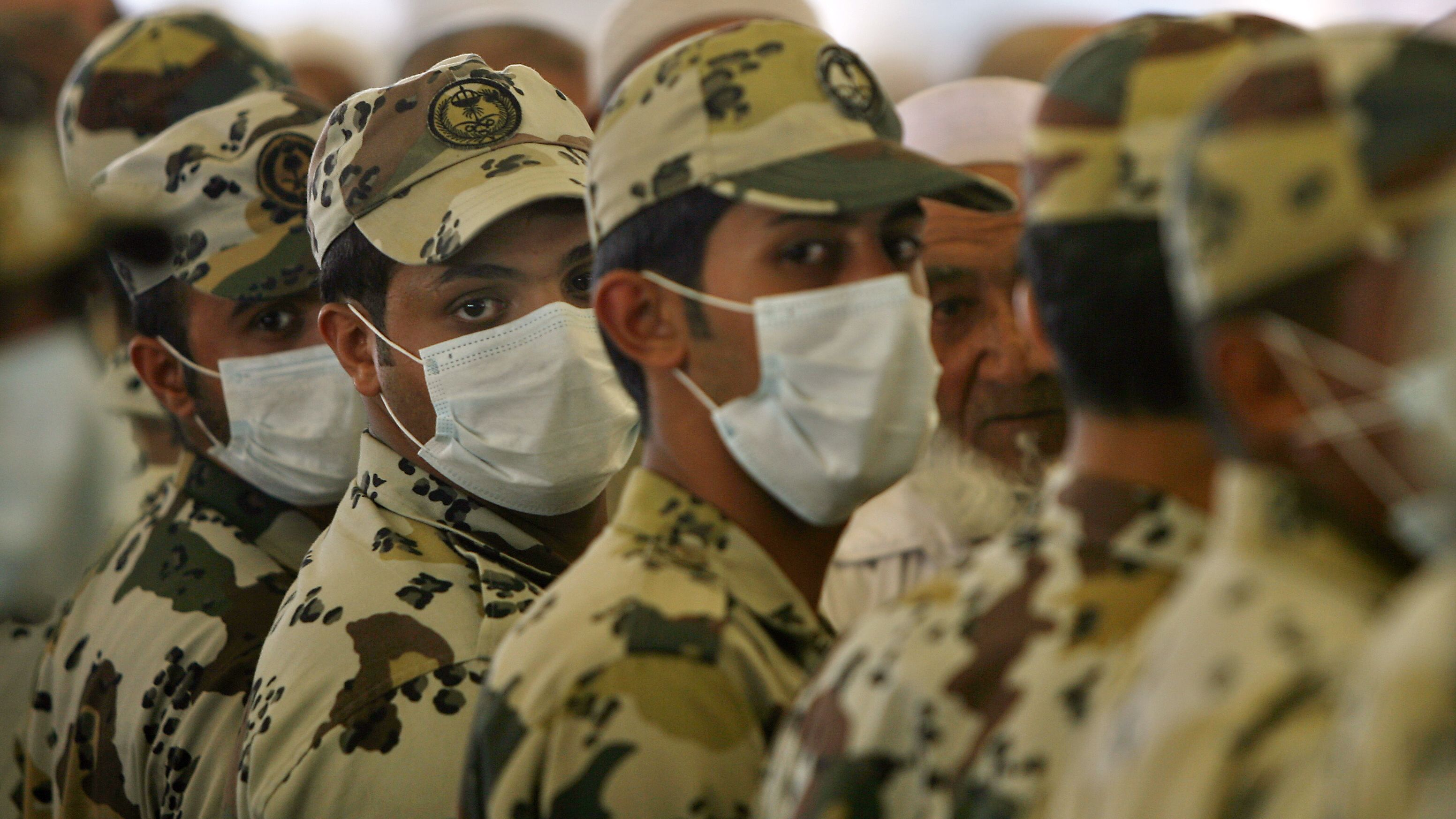 Saudi policemen, wearing protective masks against swine flu, stand guard near the holy city of Mecca on November 28, 2009.