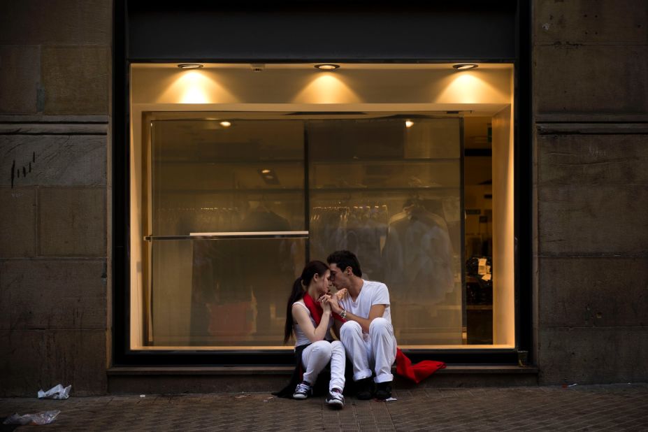 A couple kisses in front of a shop window on July 13, after the running of the bulls.