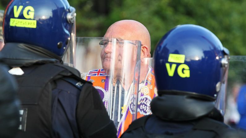 A man confronts riot police as a small protest is stopped along Shankill Road in Belfast on July 13. The Friday night protests left 32 police officers injured and required hundreds of additional officers to be sent in from Britain.