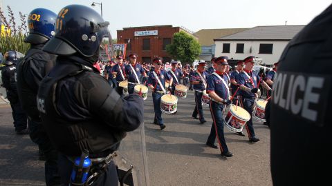 Police stand guard as Protestant Orangemen march in Belfast on July 12.