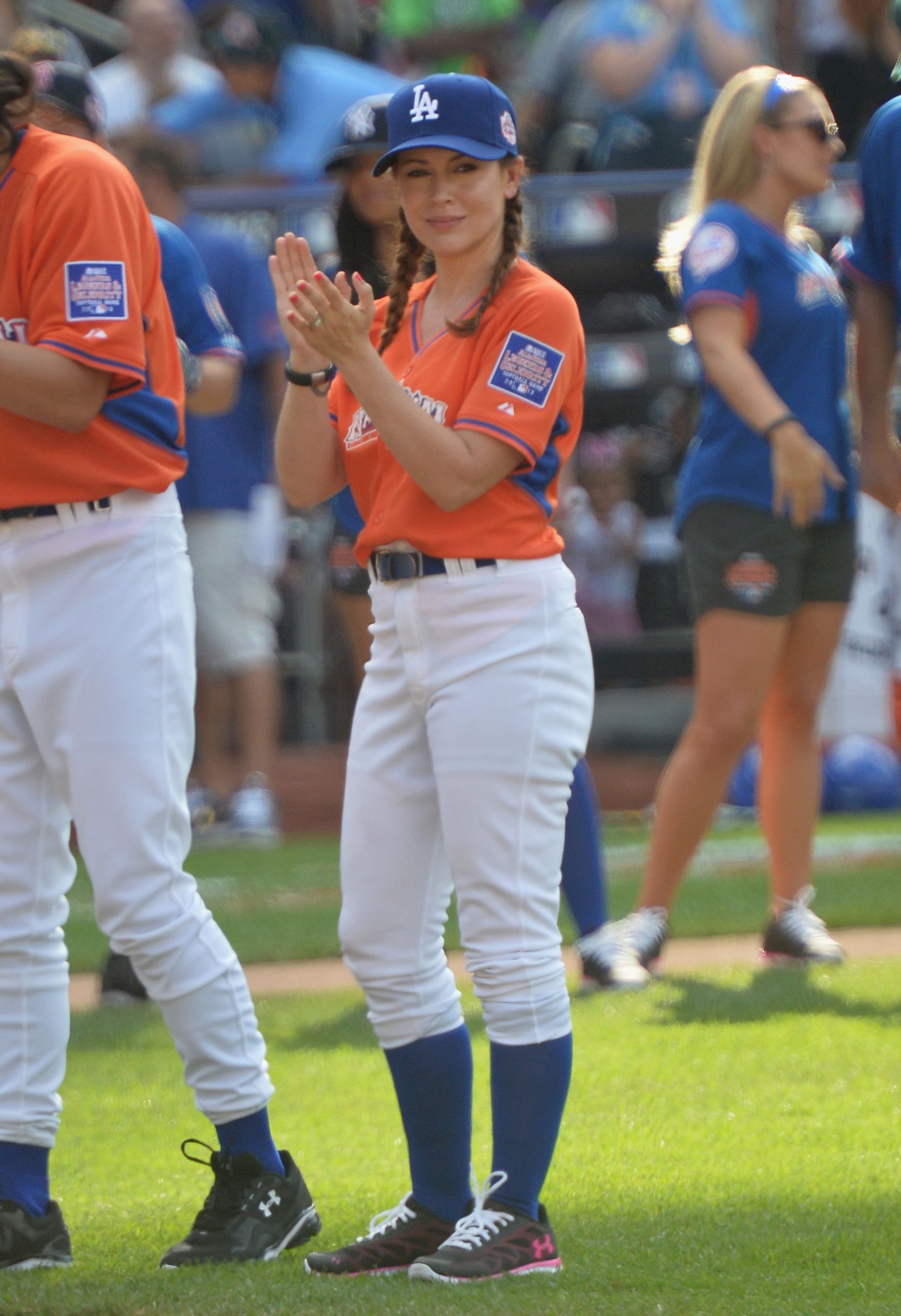 Alyssa Milano stands on the field at the All-Star Legends