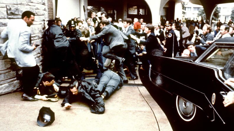 As the bullet hits Reagan, lead agent Jerry Parr grabs the president's shoulders and pushes him down into the limo.  Secret Service agent Ray Shaddick slams the door shut and the motorcade bolts from the scene.