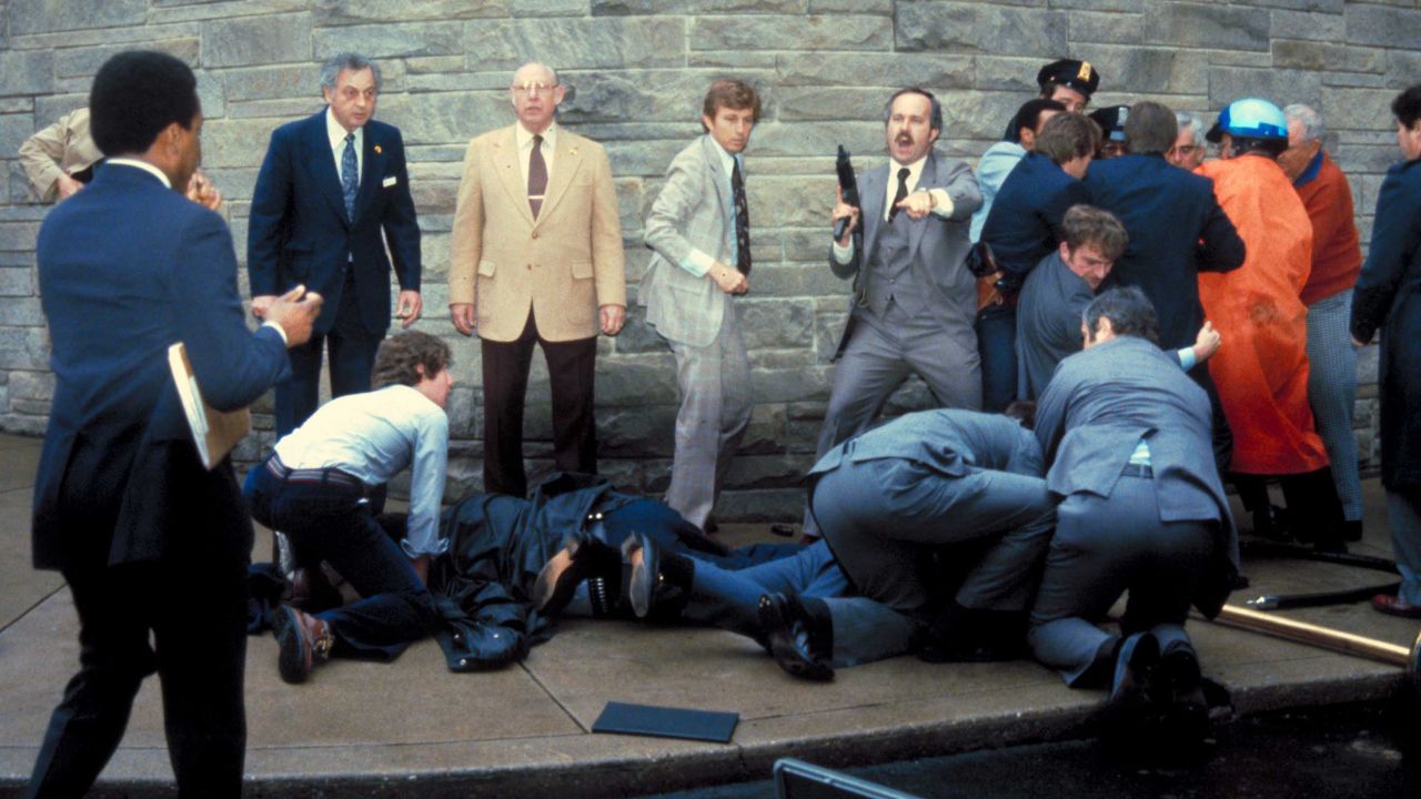 A barrage of Secret Service agents holds down Hinckley and tends to the wounded.