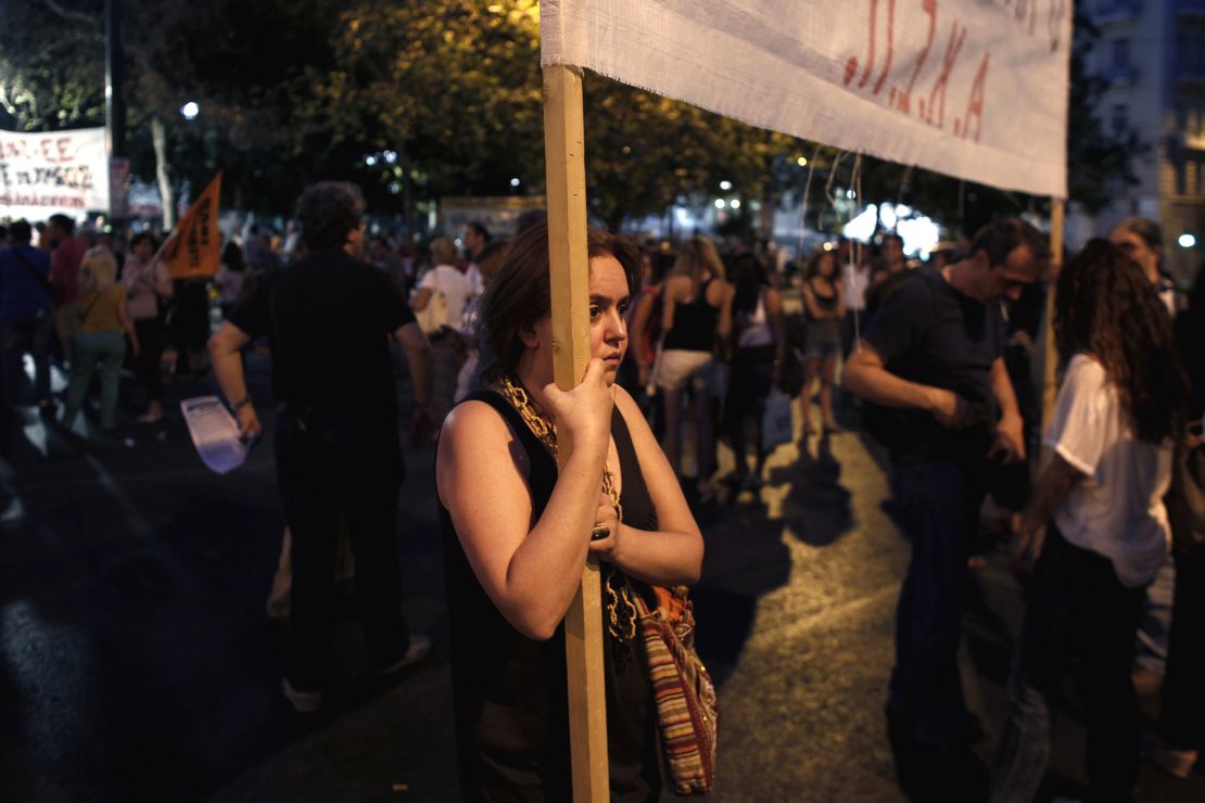 A protester, holding a banner against the Greek government, takes part in a demonstration in July 2013 in Athens.