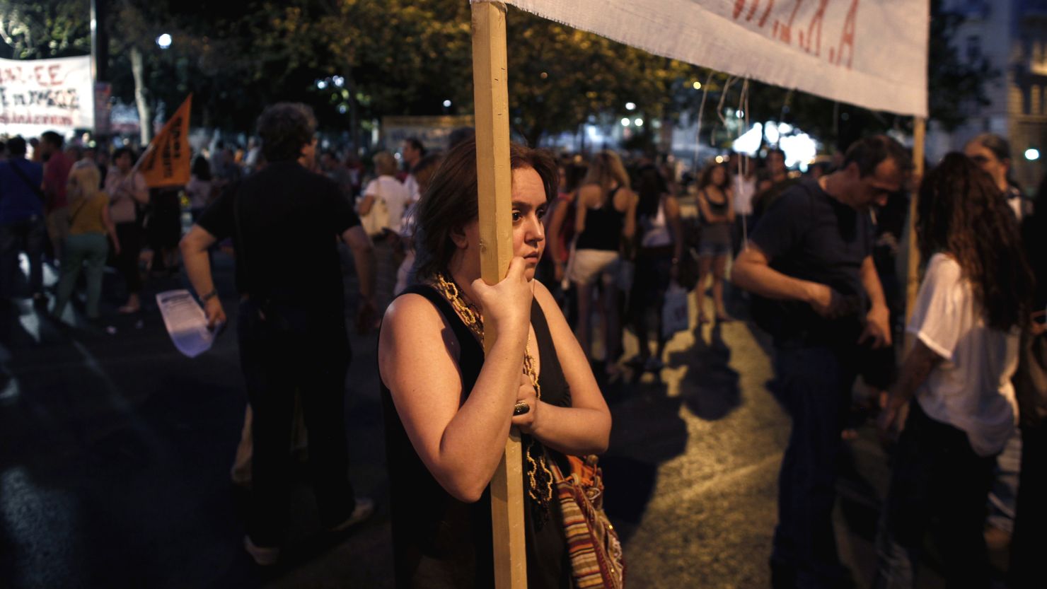 A protestor holding a banner against the Greek Government takes part in a demonstration on July 15, 2013 in Athens.