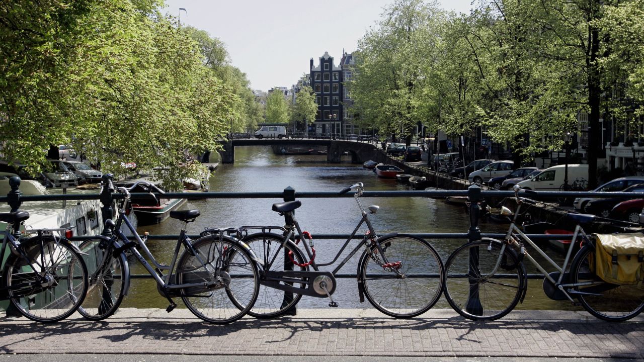 Bicycles are fixed to the railing of a bridge in Amsterdam