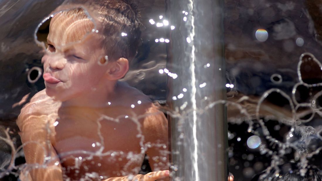 Mason Kraft, 5, keeps cool at the Highland Park Splash Pad in Cottage Grove, Minnesota, on Monday, July 15. 