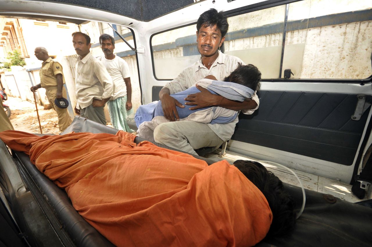 An Indian man mourns as he holds his dead daughter inside an ambulance, outside a hospital in Patna.