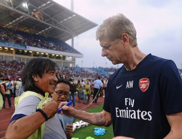 English Premier League football team Arsenal spent three days in Hanoi as part of its Asian tour. The team's manager Arsene Wenger signs a local photographer's t-shirt during a training sesssion at Hanoi's My Dinh stadium.