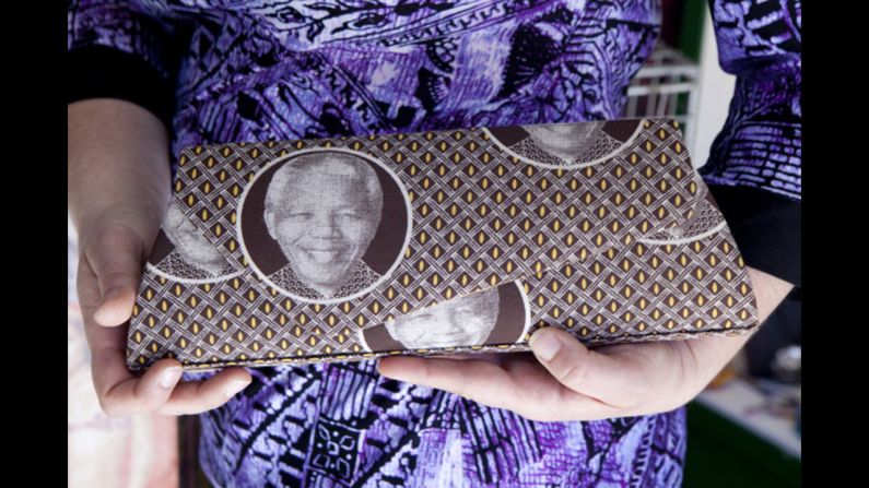 <strong>SOUTH AFRICA:</strong>  A woman holds a purse with Mandela's face on it in Johannesburg.