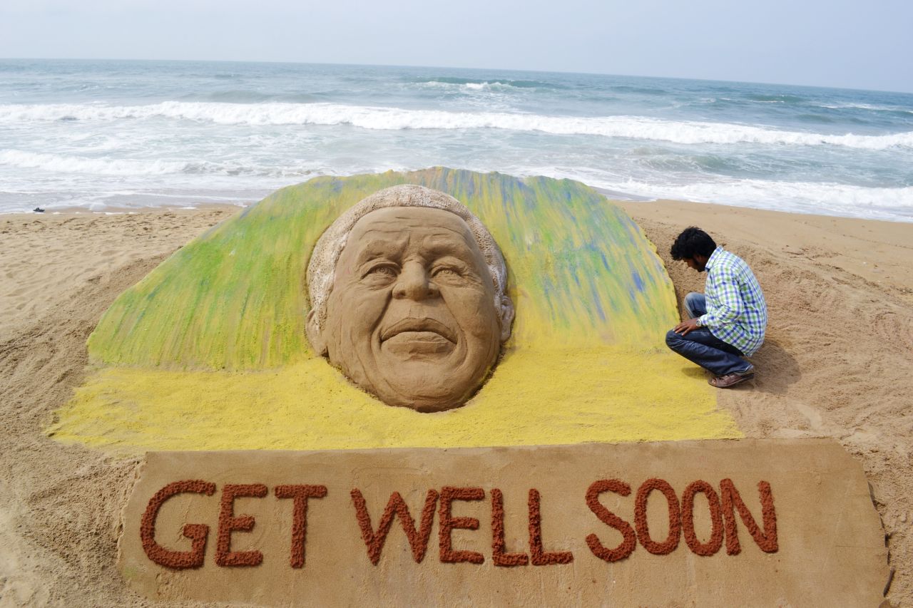 <strong>INDIA: </strong>Artist Sudarshan Pattnaik works on a sand sculpture in Puri to wish Mandela a speedy recovery. The former South African president was in critical but stable condition at the time, according to officials.
