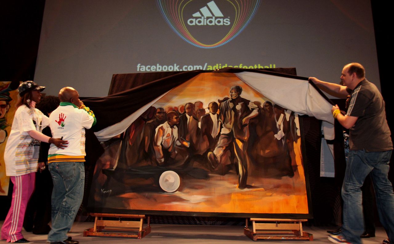 <strong>SOUTH AFRICA:</strong> From left, actress Hlubi Mboya, former boxer Baby Jake Matlala and Thomas van Schaik from Adidas unveil a piece of art during a Live Quest event showcasing paintings of key moments of the 2010 FIFA World Cup at the Adidas Jo'bulani Centre in Johannesburg. 