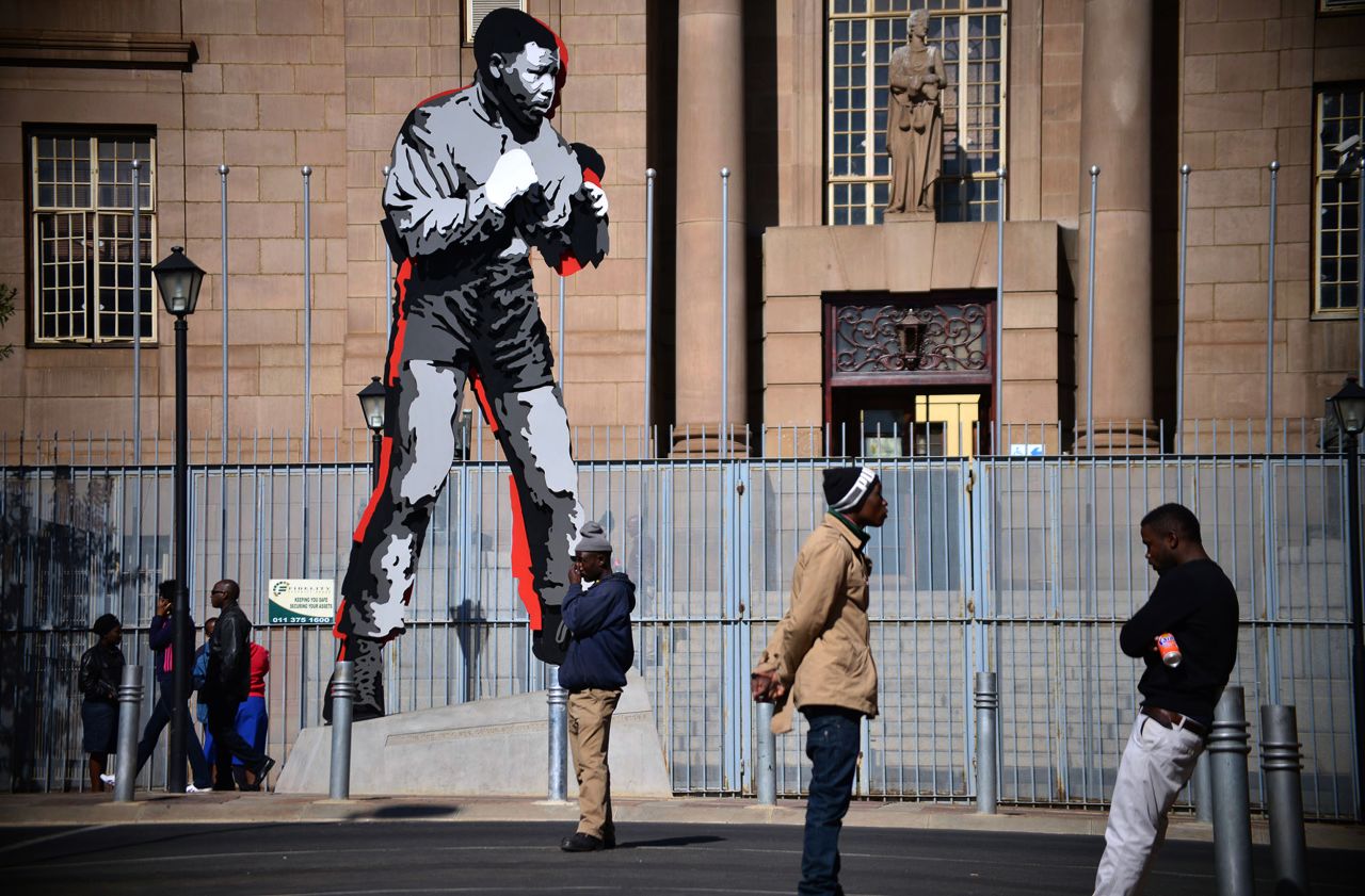 <strong>SOUTH AFRICA: </strong>People gather by a Mandela statue in downtown Johannesburg.