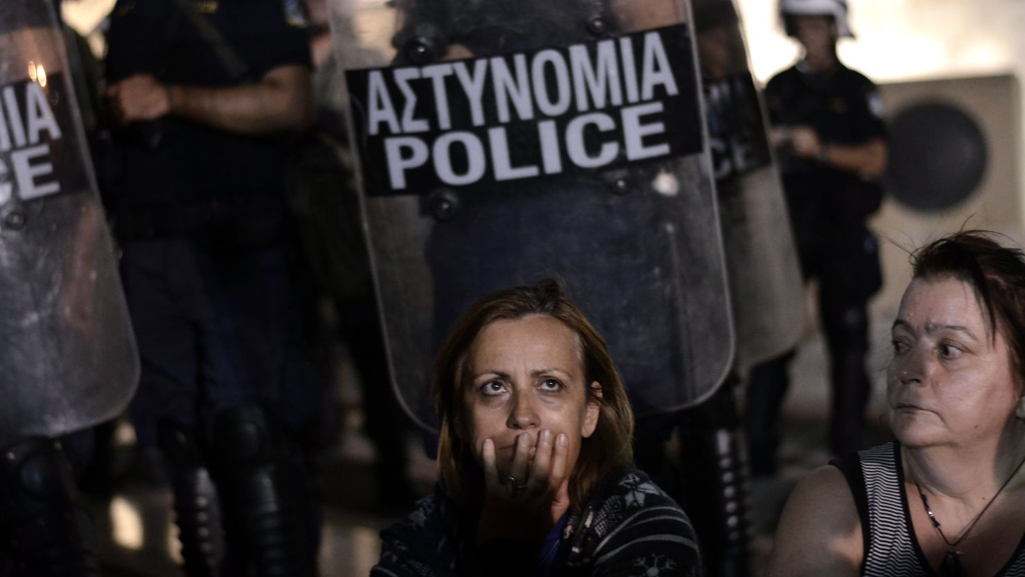 A demonstrator reacts in front of riot police as lawmakers prepared to vote on a controversial  reform involving a shake-up of civil service on Tuesday July 17. 