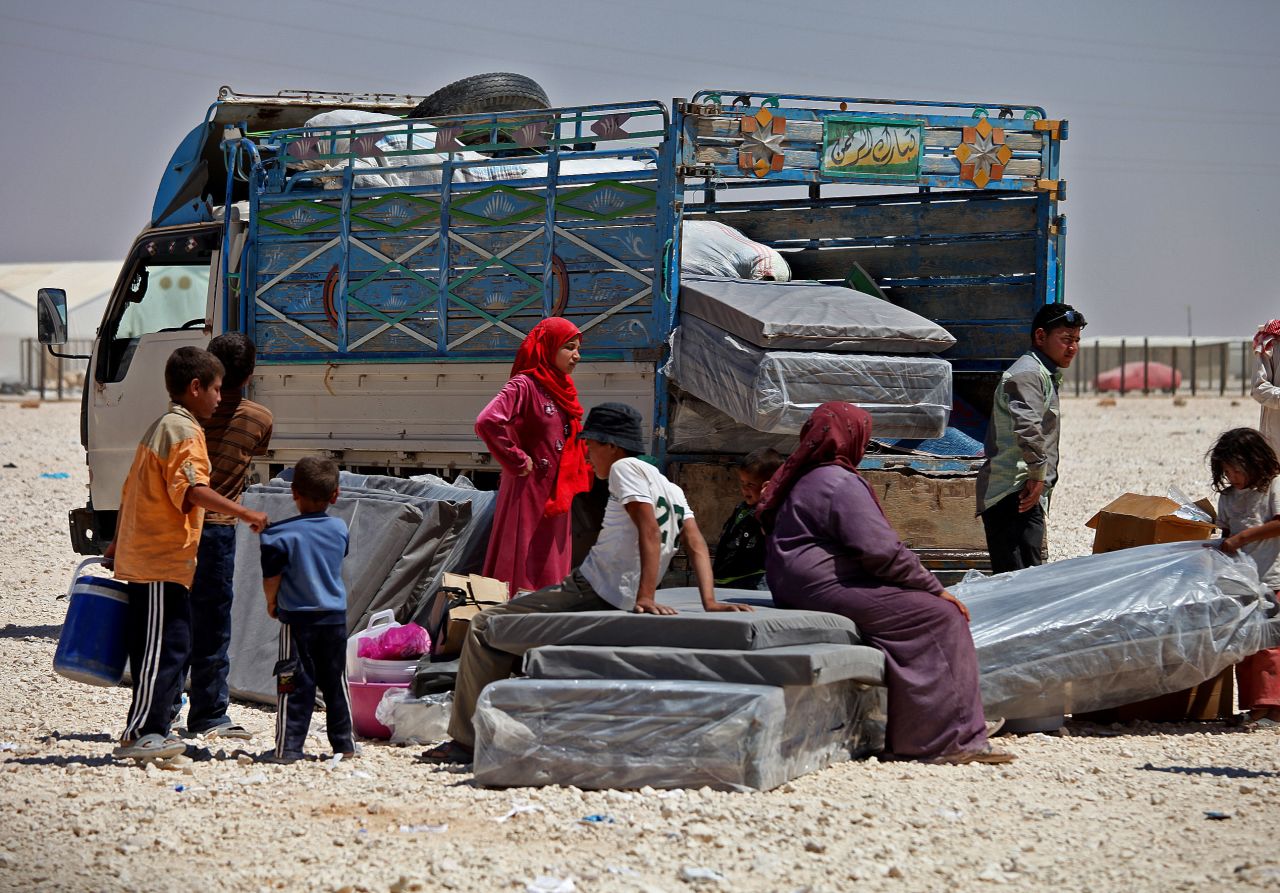 Syrian refugees stand with their belongings on June 20, World Refugee Day, at Zaatari refugee camp in Jordan.
