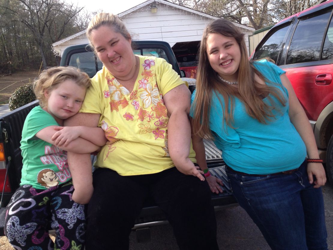 Honey Boo Boo (Alana Thompson), Mama (June Shannon), and Chubbs (Jessica Shannon) sitting on a pickup truck bed.
