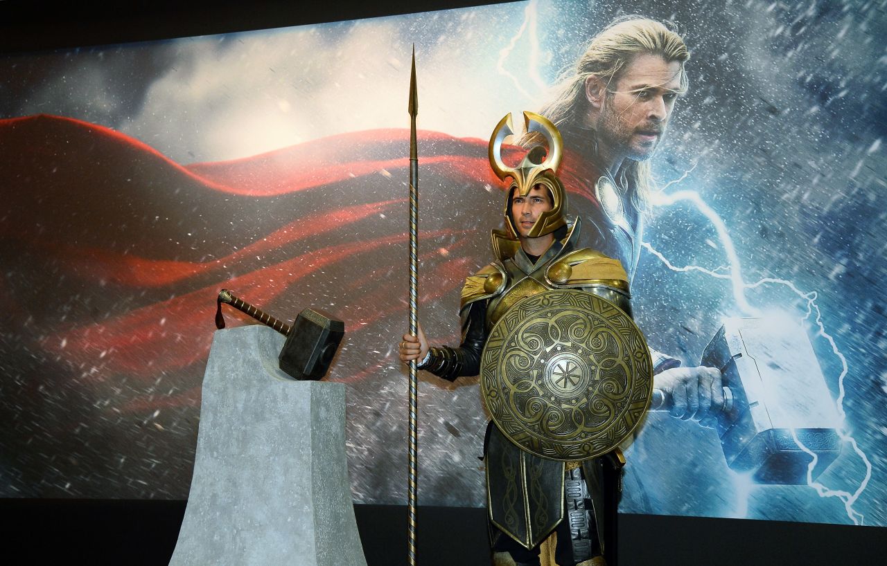 A person dressed as a character from "Thor: The Dark World" stands guard in front of a display for the movie.