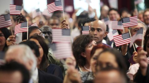 New Americans wave flags at a naturalization ceremony in  Manhattan on July 2 in New York City. 
