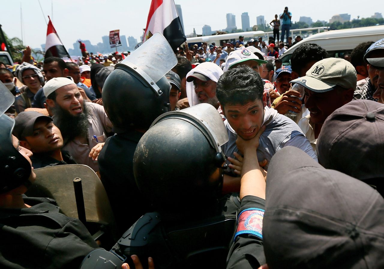 A Morsy supporter is held back by riot police during a rally near Tahrir Square on July 17.