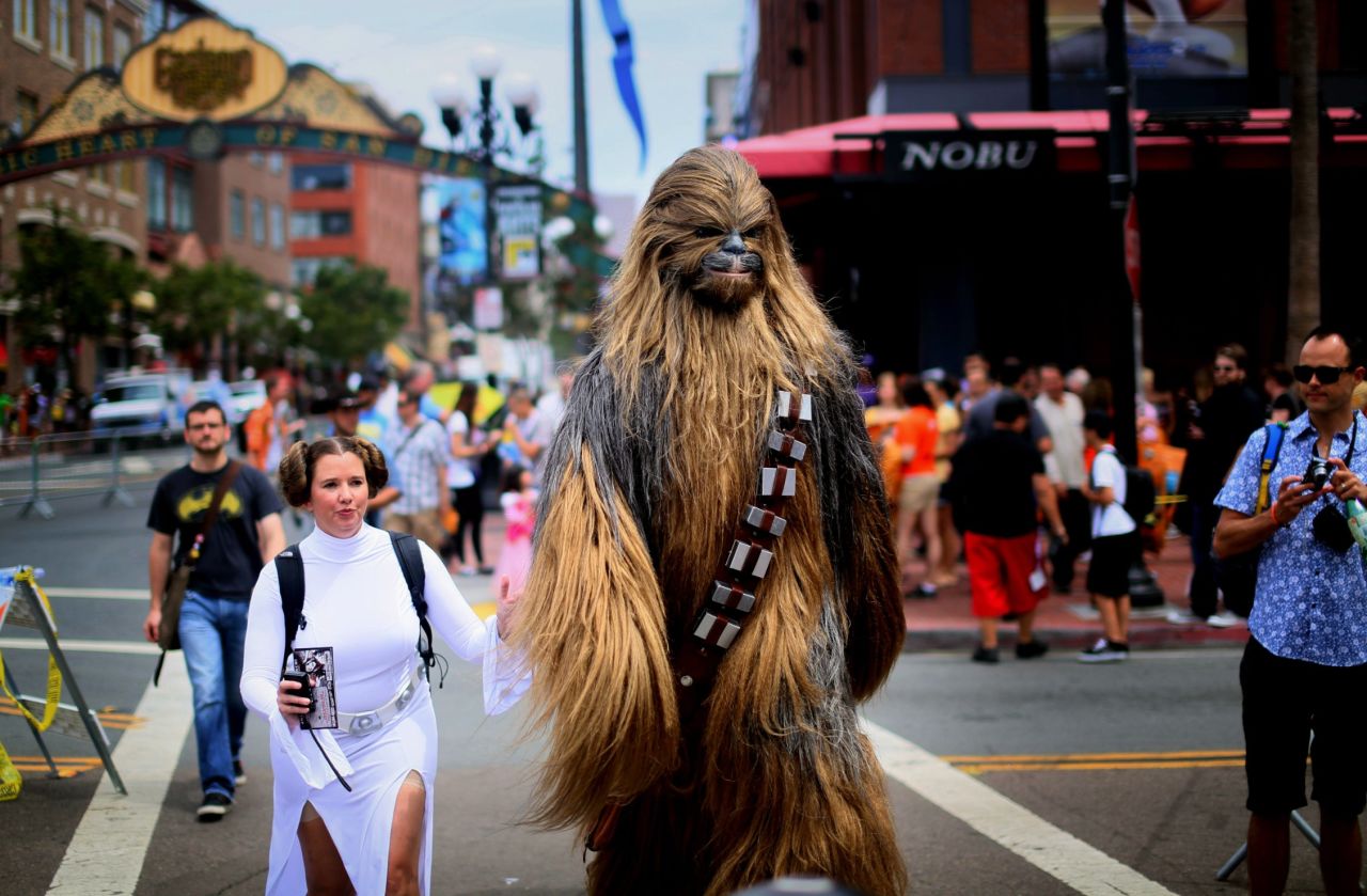 Fans dressed as "Star Wars" characters Princess Leia and Chewbacca walk down San Diego's 5th Avenue.