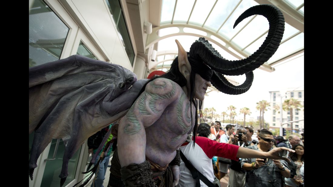An attendee in an elaborate costume makes his way through a crowd outside the San Diego Convention Center on July 19.
