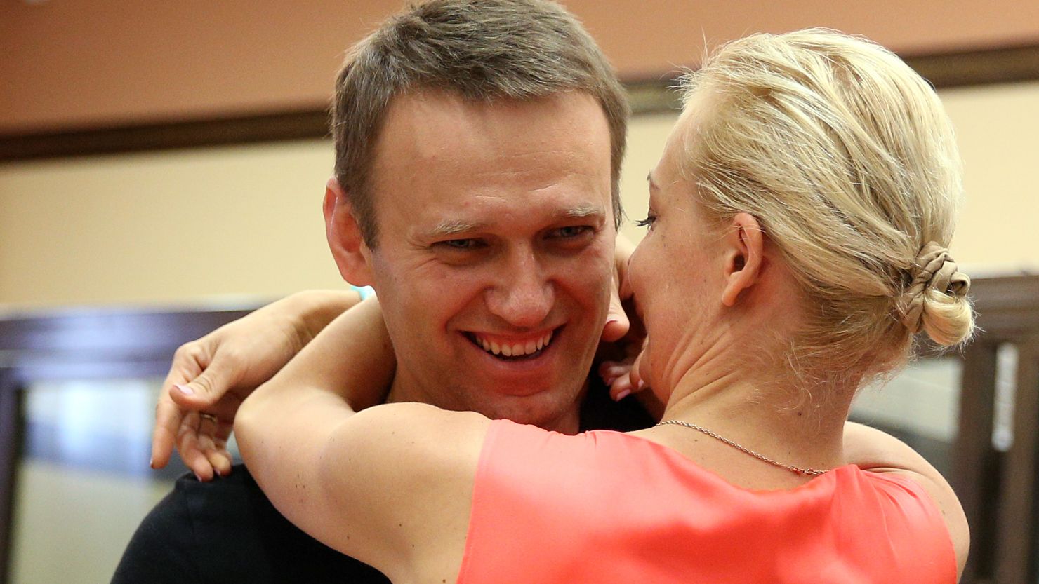 Russia's top opposition leader Alexei Navalny hugs his wife Yulia in the courtroom in Kirov on July 19, 2013.