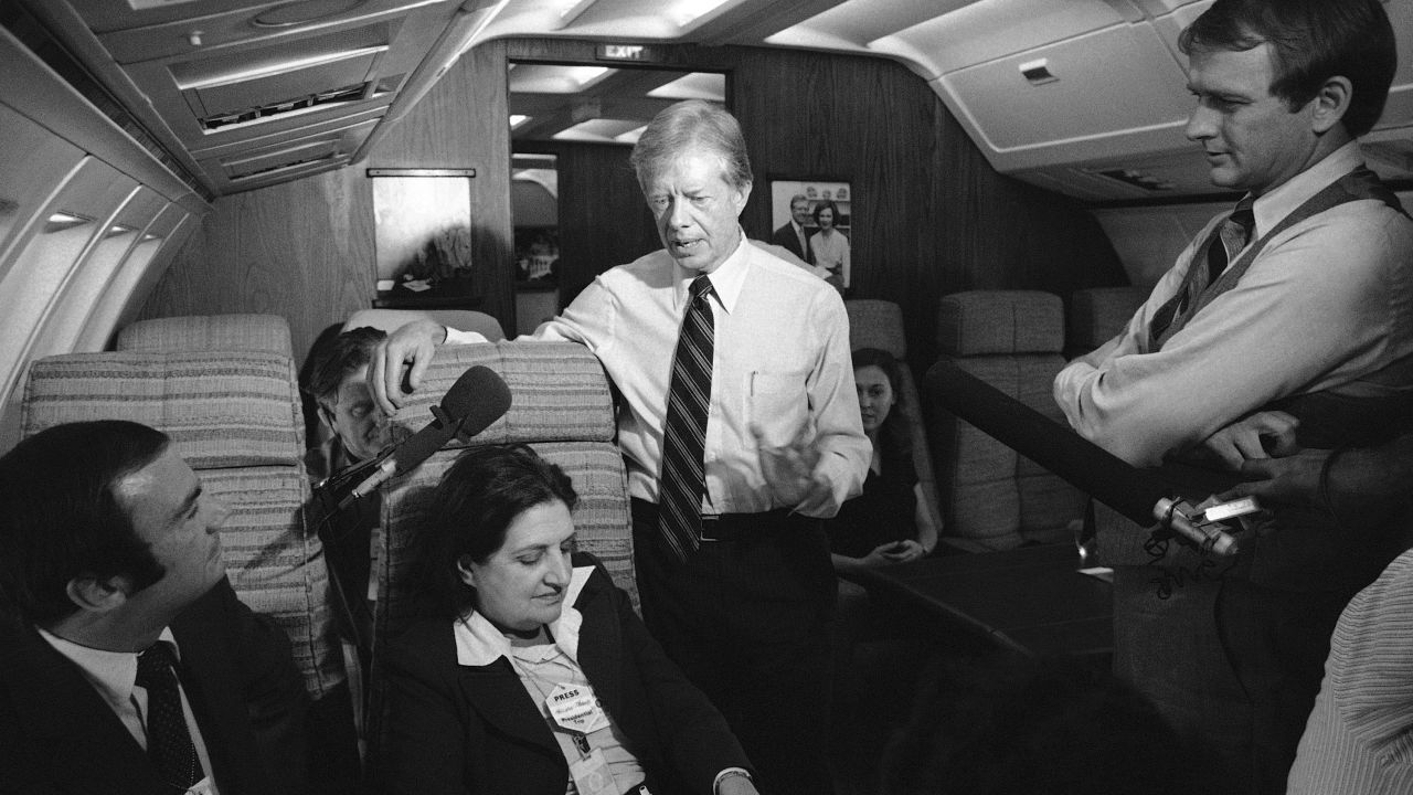 President Jimmy Carter and press secretary Jody Powell, right, chat with reporters, including Thomas, on Air Force One on October 20, 1979.