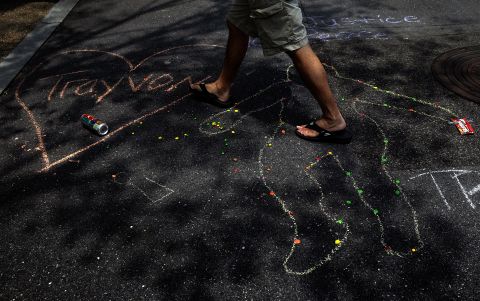 A chalk outline, a bag of Skittles, and a can of iced tea are seen during the vigil outside the E. Barrett Prettyman Federal Courthouse in Washington, D.C., on July 20.