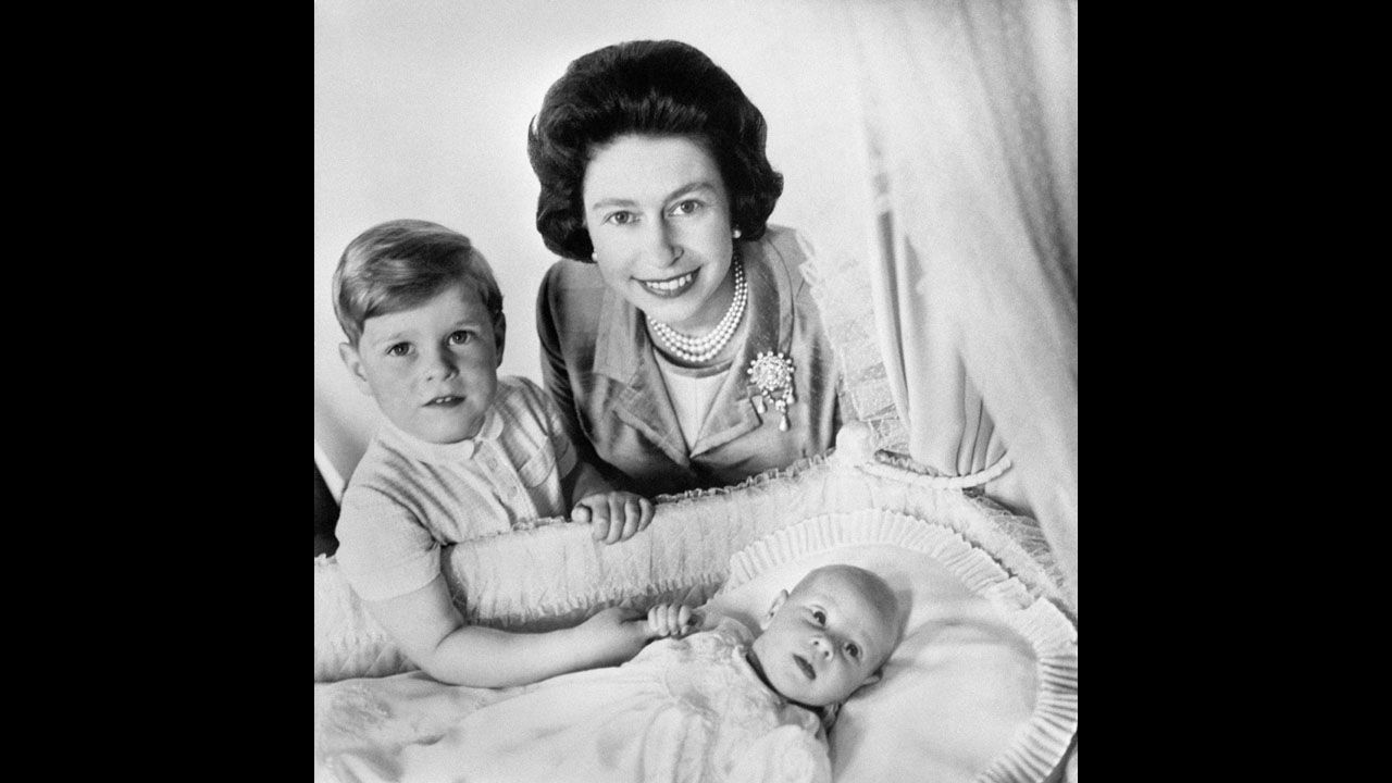 Queen Elizabeth II and Prince Andrew with newborn Prince Edward, the queen's fourth child, in Buckingham Palace's music room in June 1964.