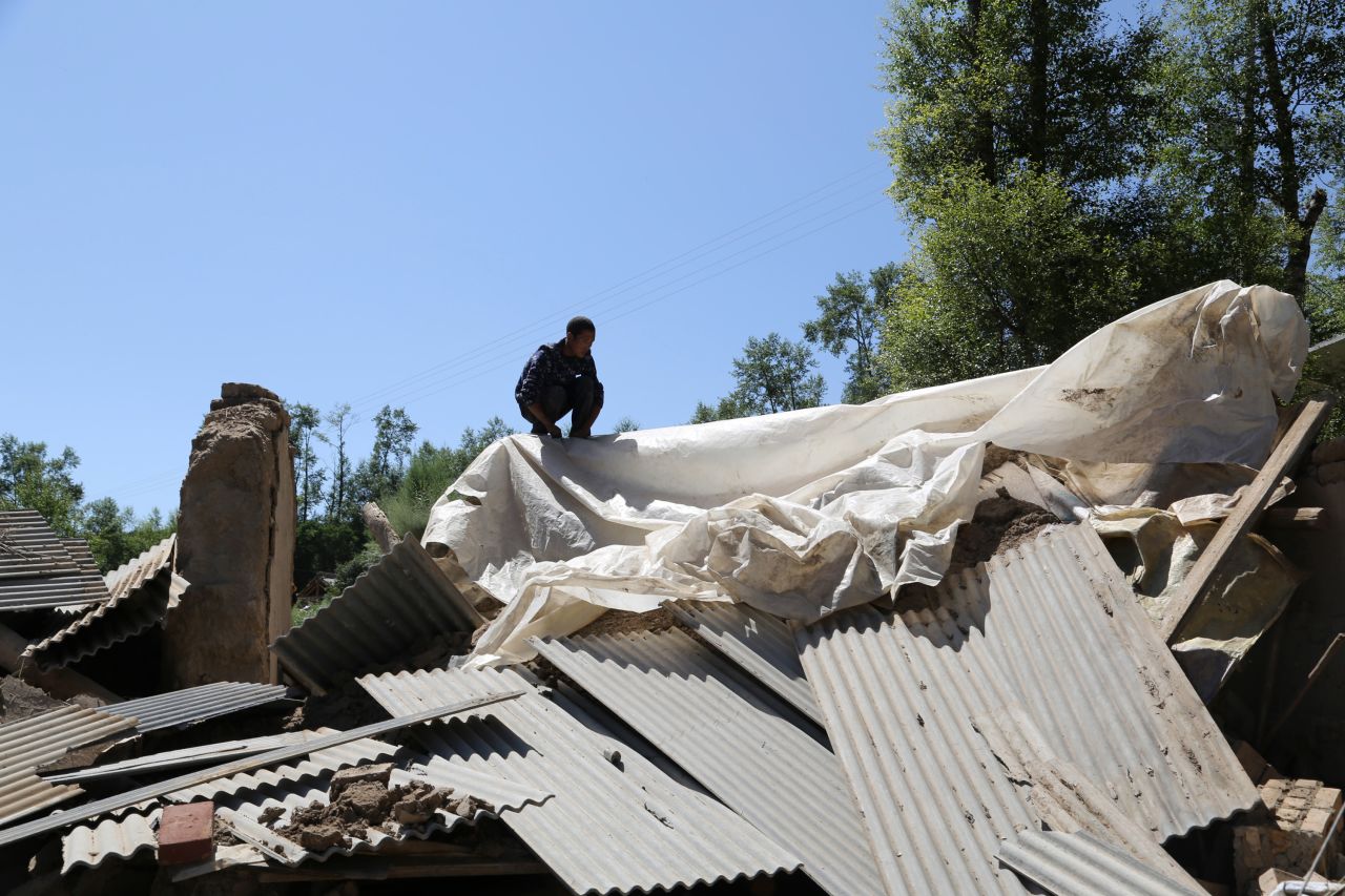 A man checks out a damaged house in Hetuo township in Dingxi in China's Gansu Province on Monday, July 22.
