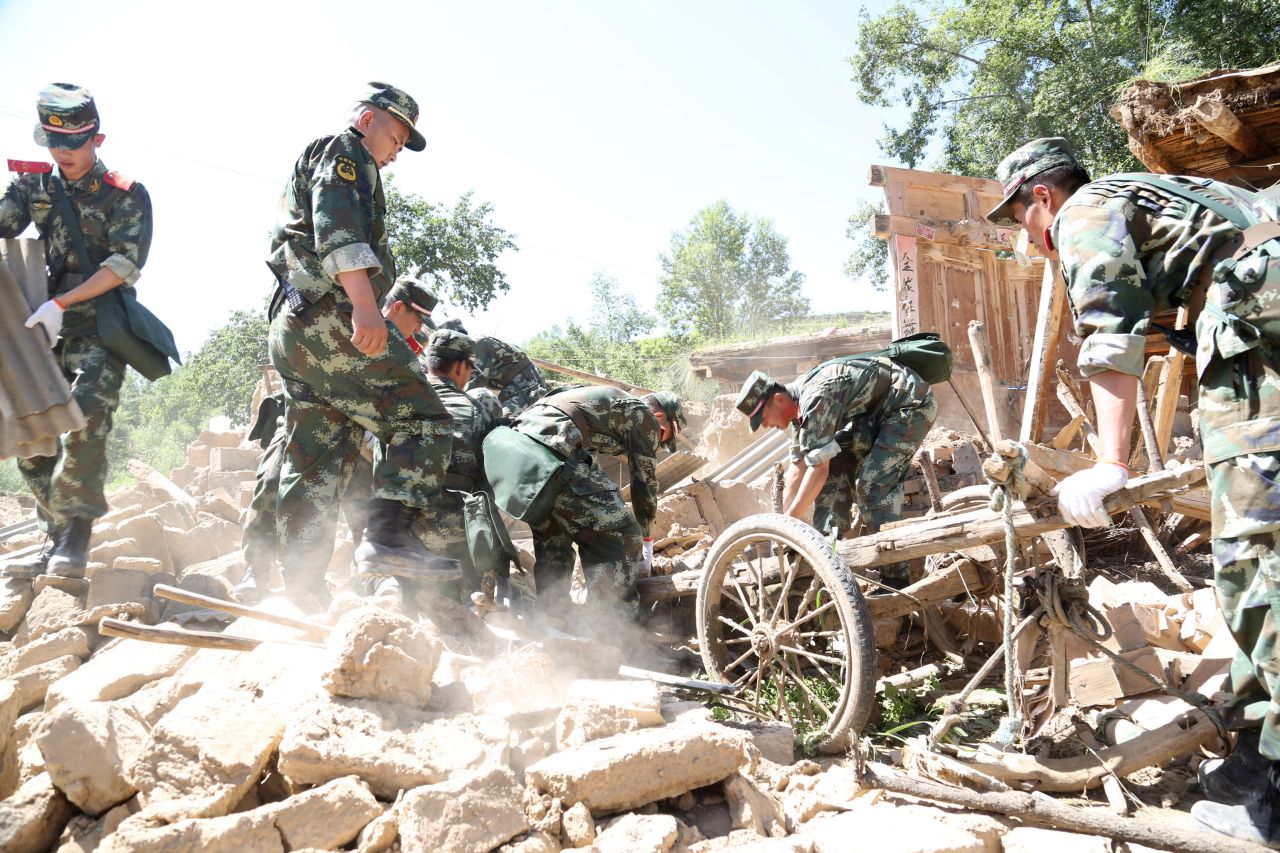 Rescuers look for survivors in the ruins of a house in Hetuo township in Dingxi on July 22. Emergency services are converging on the area, including the Red Cross Society of China, which is sending 200 tents and other supplies to help those left homeless.