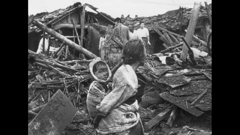 A woman and child wander among debris in Pyongyang, North Korea, after an air raid by U.S. planes, circa 1950. The war began on June 25, 1950, when the North Korean People's Army crossed the 38th parallel and easily overwhelmed South Korean forces in a surprise attack. 