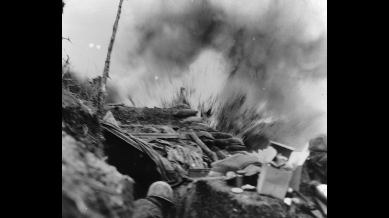 U.S. Marines duck for cover in a bunker as a shell explodes in April 1952.