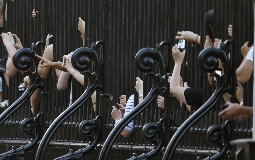 Revelers crowd against the railing of Buckingham Palace in London after an official notice proclaiming the birth was put on display on July 22.