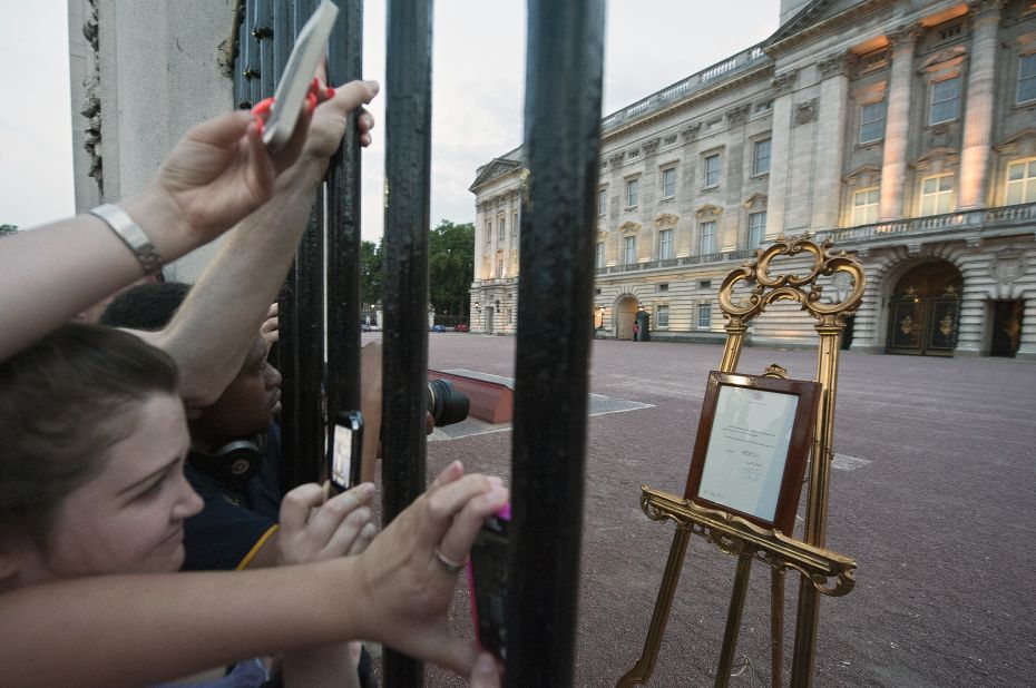 People clamor for their chance to see and photograph the birth announcement that was placed on a golden easel by the queen's press secretary on July 22.