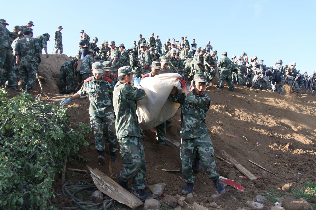 Military personnel work on a hillside in Yongguang in Minxian County on Monday, July 22.